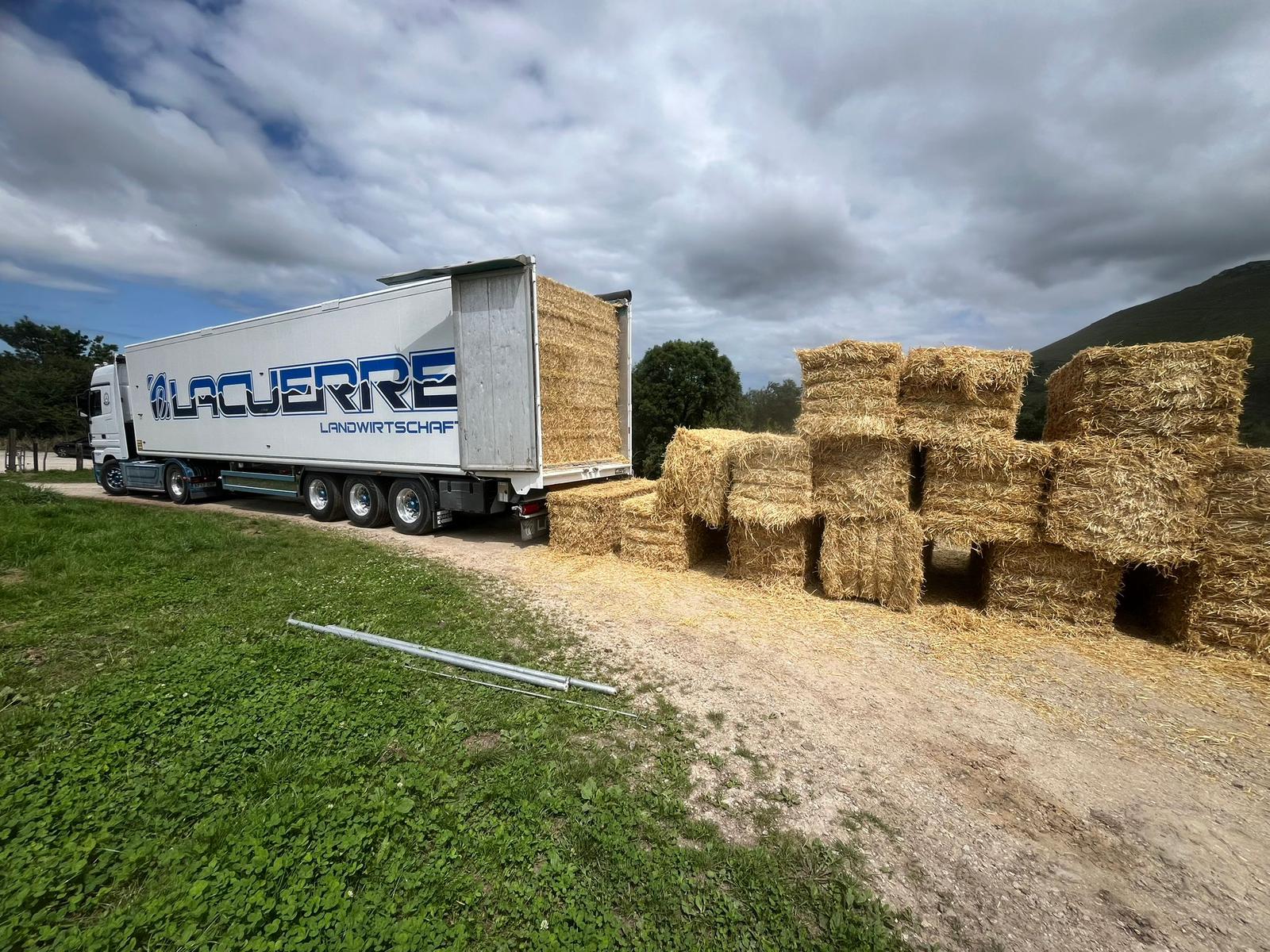 Camión Mercedes-Benz Actros de Lacuerre Landwirtschaft cargando pacas de paja en campo agrícola