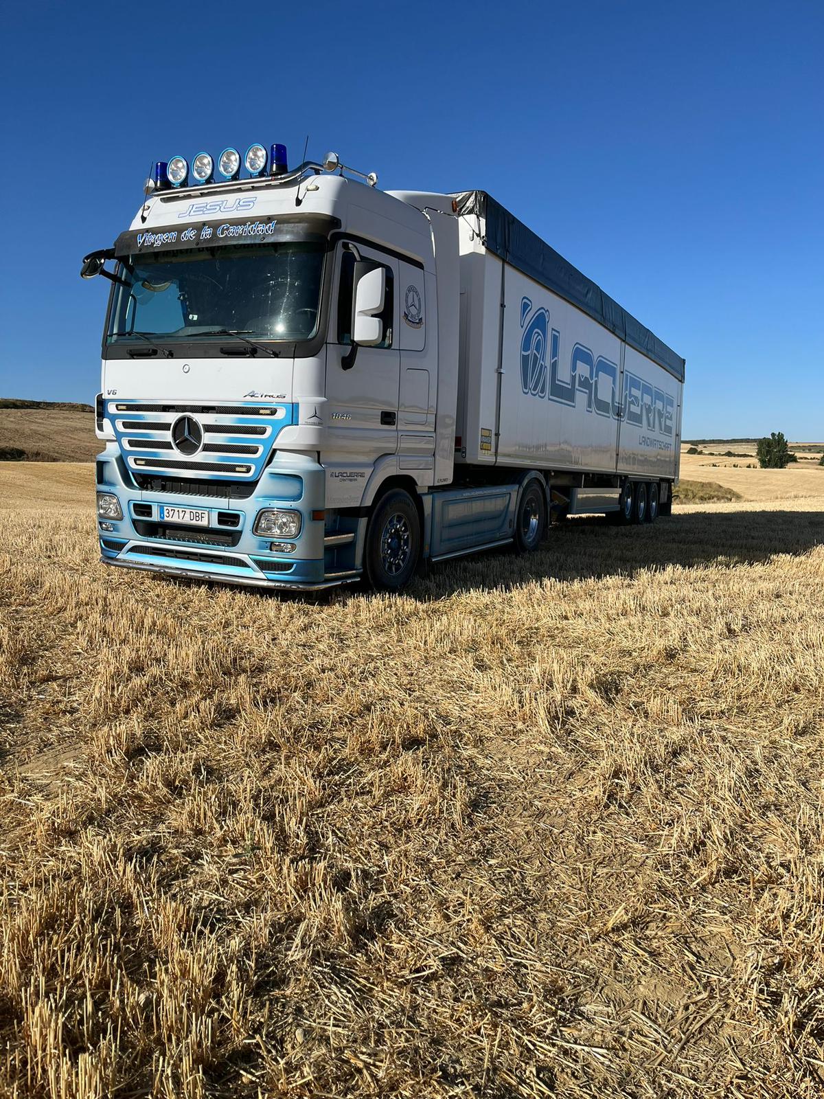 Camión Mercedes-Benz Actros de Lacuerre Landwirtschaft en campo agrícola con paisaje de fondo